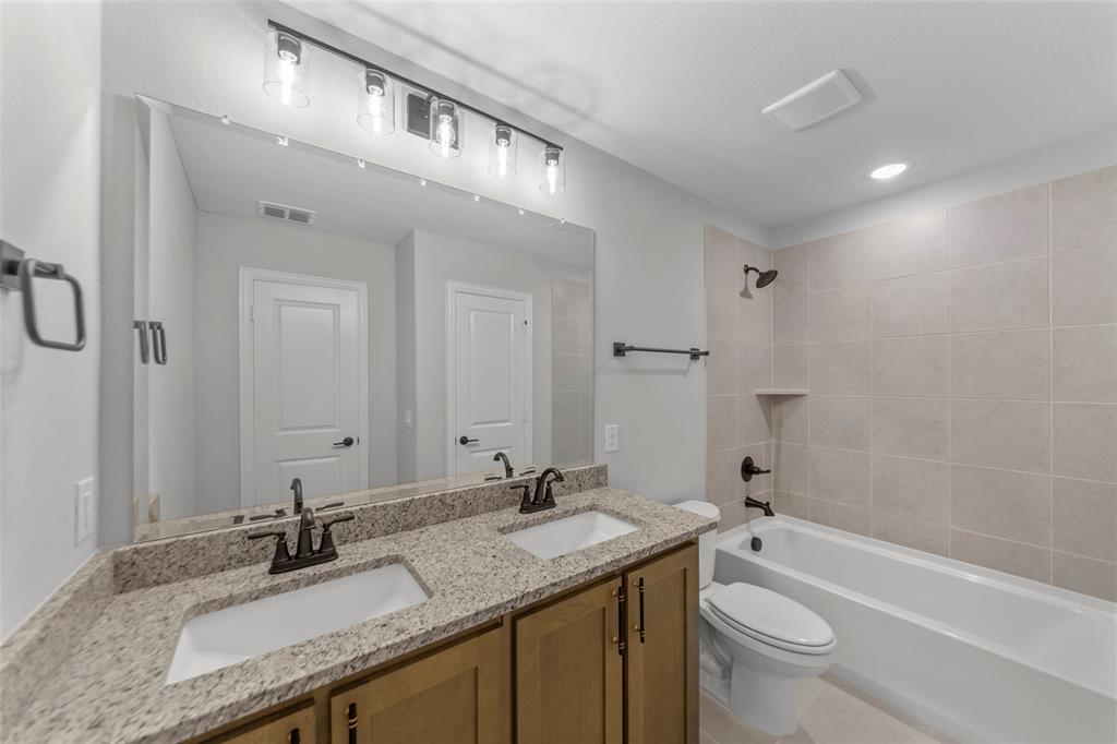 3405 Heathrow Road Mesquite, TX 75181 - Photo 25 of 30 a bathroom with a granite countertop sink a toilet and bathtub