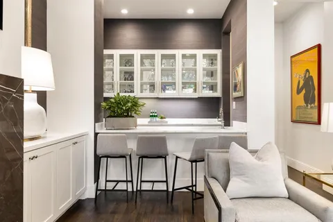 a living room with furniture kitchen view and a chandelier