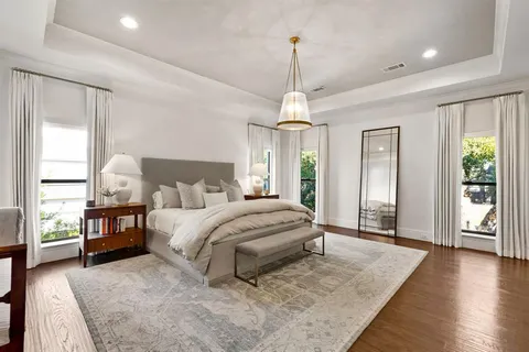 a bedroom with a bed and a flat tv screen on dresser