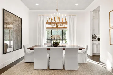 a large living room with stainless steel appliances kitchen island granite countertop a couch a dining table and chairs