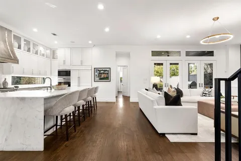 a kitchen with stainless steel appliances granite countertop a table chairs refrigerator and sink