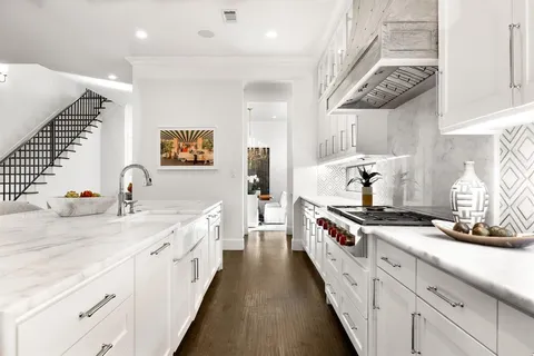 a kitchen with stainless steel appliances granite countertop a stove and a white cabinets