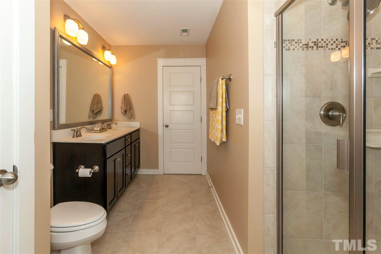 7811 Lillyhurst Drive Raleigh, NC 27612 - Photo 16 of 25 a bathroom with a sink a toilet a mirror and shower