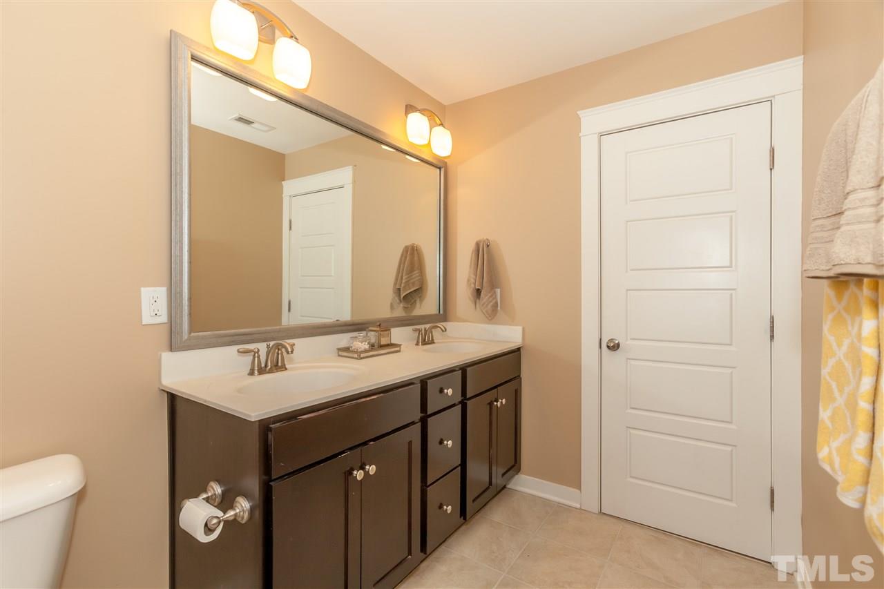 7811 Lillyhurst Drive Raleigh, NC 27612 - Photo 17 of 25 a bathroom with a sink mirror vanity and toilet