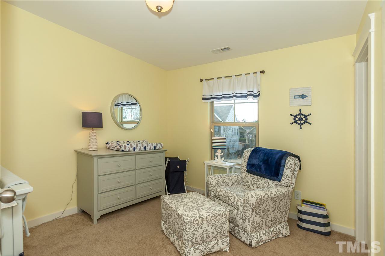 7811 Lillyhurst Drive Raleigh, NC 27612 - Photo 18 of 25 a bedroom with a bed and a chair