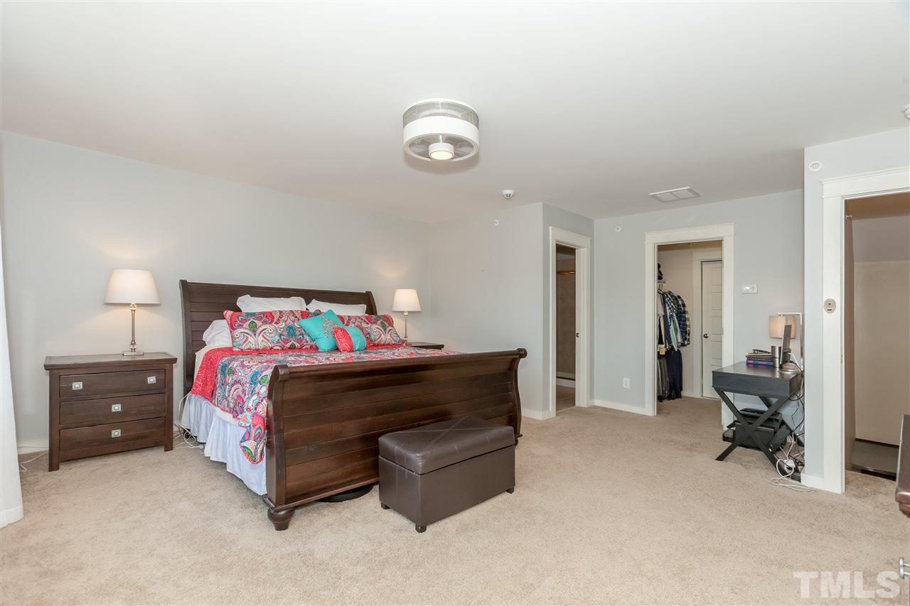 7811 Lillyhurst Drive Raleigh, NC 27612 - Photo 21 of 25 a spacious bedroom with a bed and a lamp on table