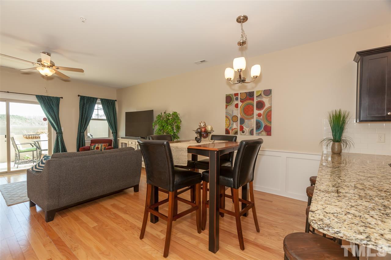 7811 Lillyhurst Drive Raleigh, NC 27612 - Photo 5 of 25 a dining room with furniture a chandelier and wooden floor