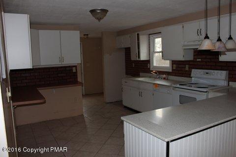 1612 Silver Maple Road Effort, PA 18330 - Photo 18 of 27 a kitchen with stainless steel appliances granite countertop a stove a sink and a refrigerator