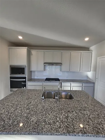 a kitchen with a stove a sink and a refrigerator