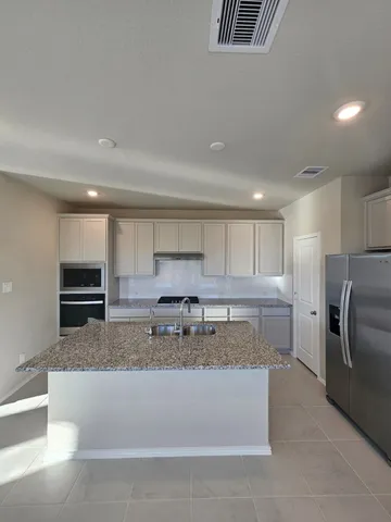 a kitchen with a refrigerator sink and stove