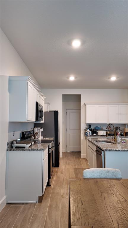 8599 Sportsman Loop Groveland, FL 34736 - Photo 7 of 19 a kitchen with stainless steel appliances a stove a sink dishwasher a refrigerator and a microwave