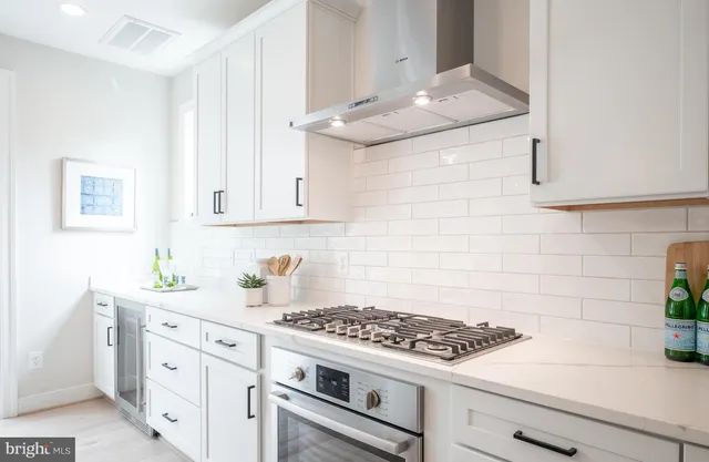 a kitchen with white cabinets and appliances