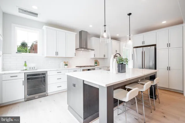 a kitchen with a sink a stove a refrigerator and white cabinets
