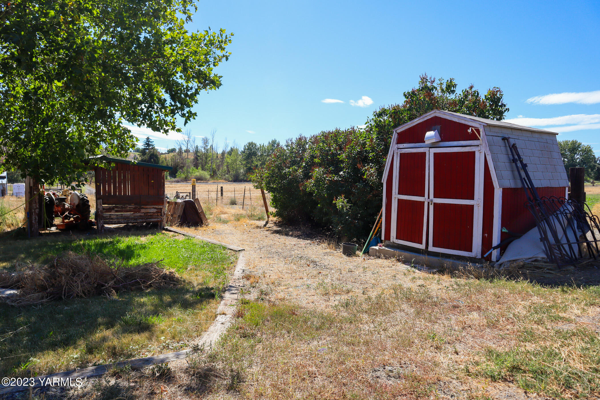 211 Cook Road Yakima, WA 98908 - Photo 15 of 23 a view of backyard with table and chairs a barbeque and a large trees