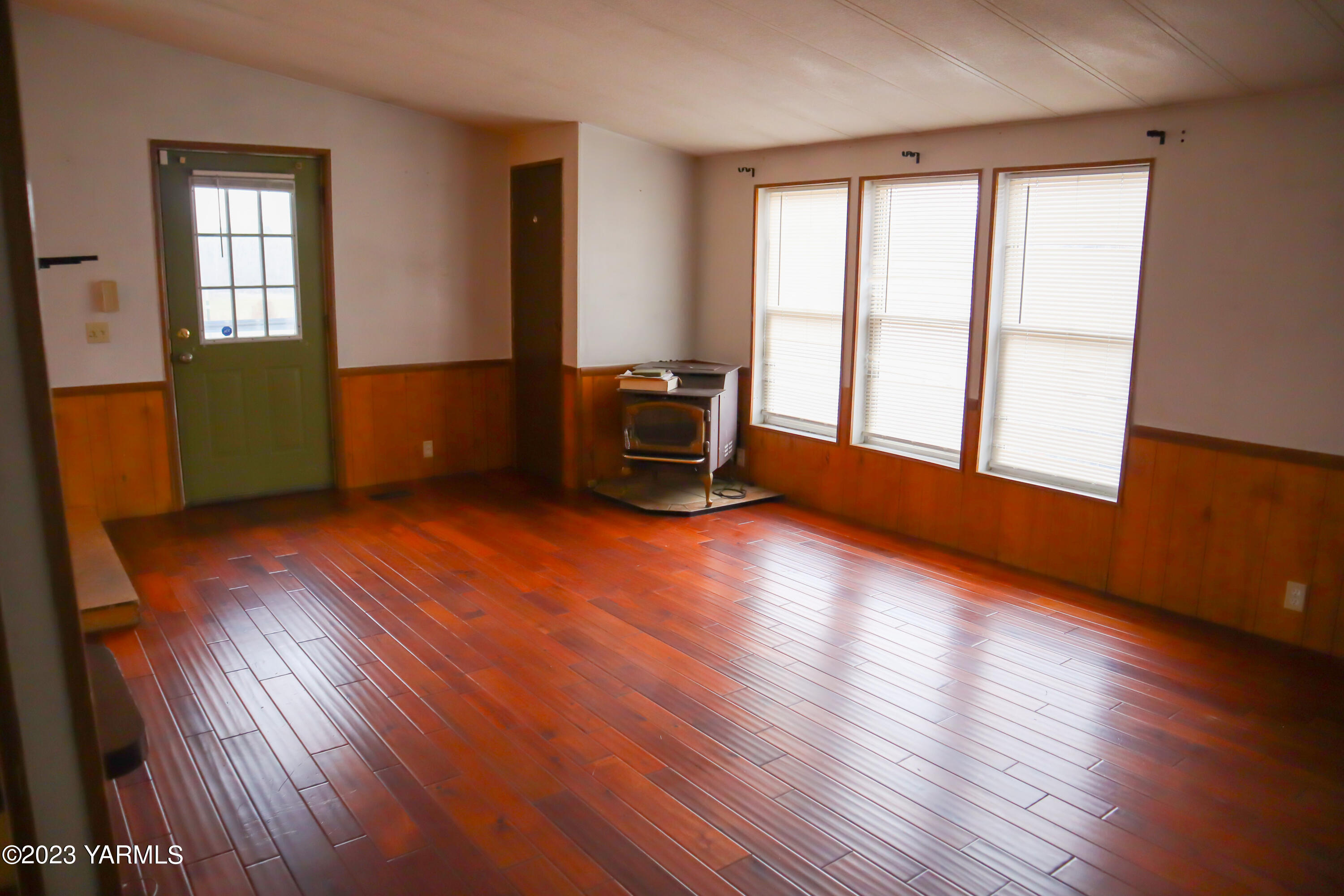 211 Cook Road Yakima, WA 98908 - Photo 3 of 23 an empty room with wooden floor and windows