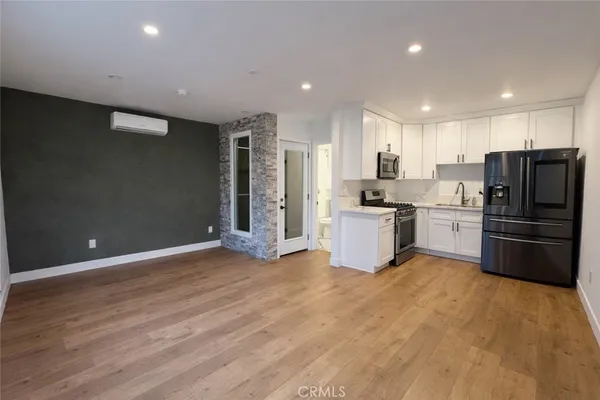 a kitchen with granite countertop a refrigerator and a stove top oven