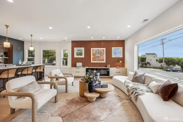 a kitchen with kitchen island a dining table chairs and white cabinets