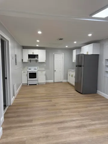 a view of kitchen with kitchen island a refrigerator and a stove top oven