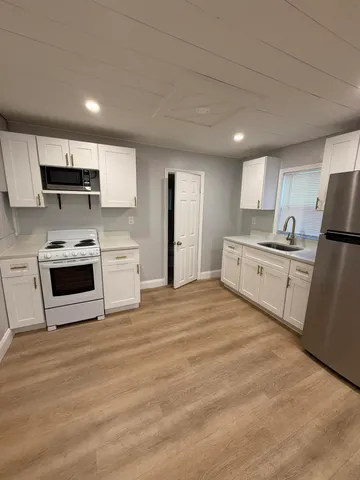 a large kitchen with a stove a sink and a refrigerator
