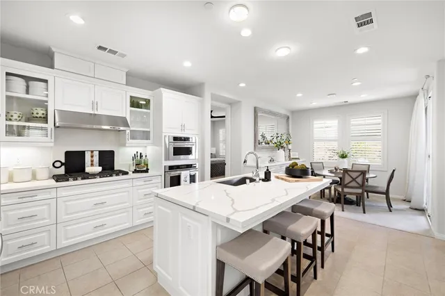 a large kitchen with kitchen island a dining table and chairs