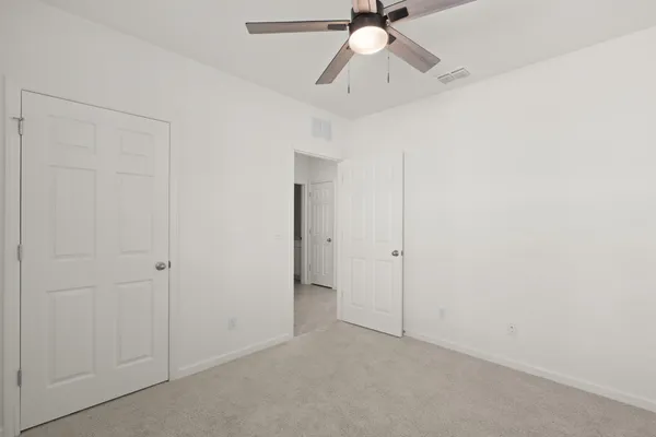 an empty room with a ceiling fan and a fan