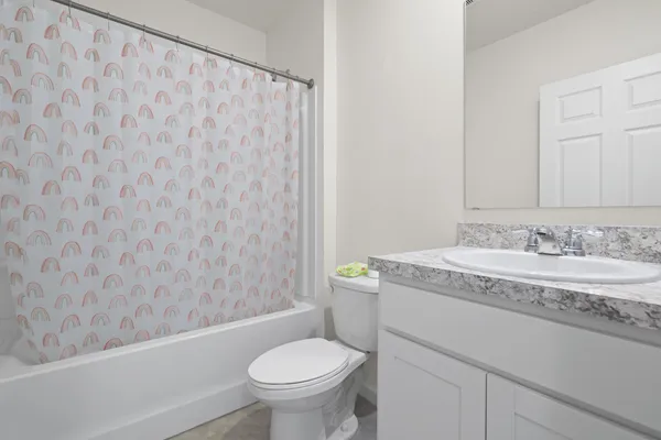a bathroom with a granite countertop sink toilet and a mirror