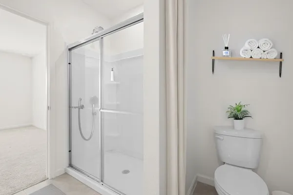 a bathroom with a shower a toilet and a shower