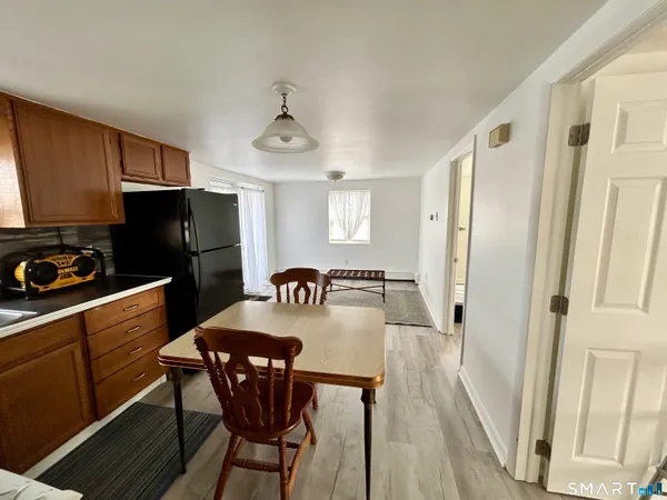 a kitchen with stainless steel appliances granite countertop a refrigerator a stove a sink dishwasher and a refrigerator with wooden floor