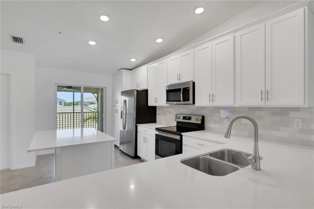 6047 Ellerston Way, Unit 2125 Ave Maria, FL 34142 - Photo 5 of 41 Kitchen with island and abundance of cabinets, slider to front screened patio space.