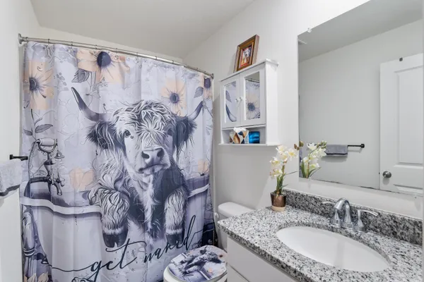 a bathroom with a granite countertop tub sink and mirror
