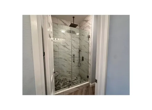 a open hall with a floor to ceiling window and a wooden floor