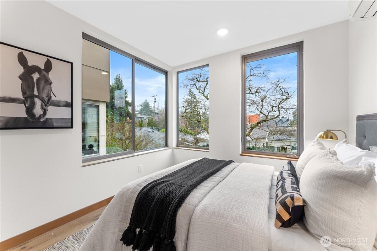 5017 Fauntleroy Way Southwest, Unit B Seattle, WA 98136 - Photo 17 of 24 a bedroom with a bed and a painting on the wall