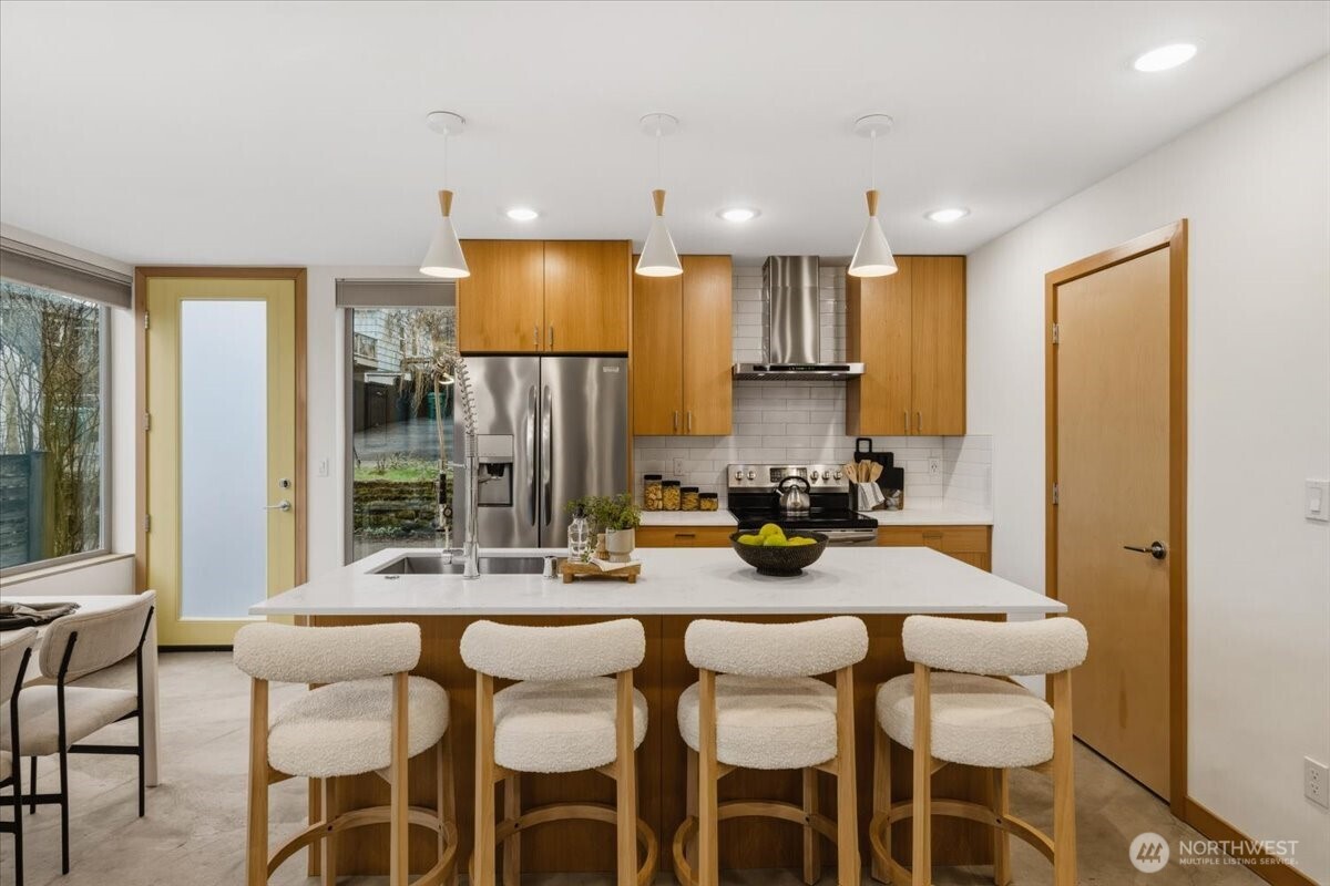 5017 Fauntleroy Way Southwest, Unit B Seattle, WA 98136 - Photo 5 of 24 a kitchen with a dining table chairs and refrigerator