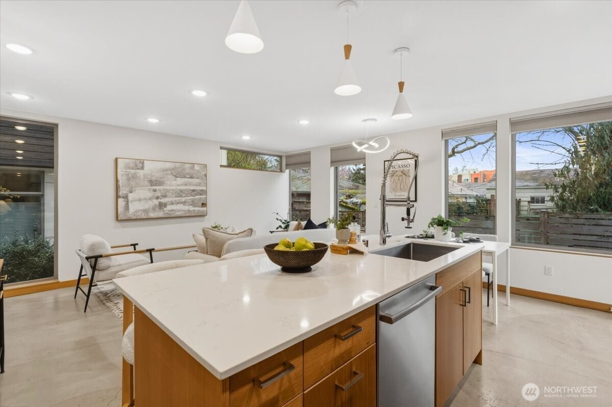 5017 Fauntleroy Way Southwest, Unit B Seattle, WA 98136 - Photo 6 of 24 a kitchen with stainless steel appliances a sink a counter top space and living room view