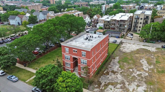 an aerial view of a house with garden space and trees all around