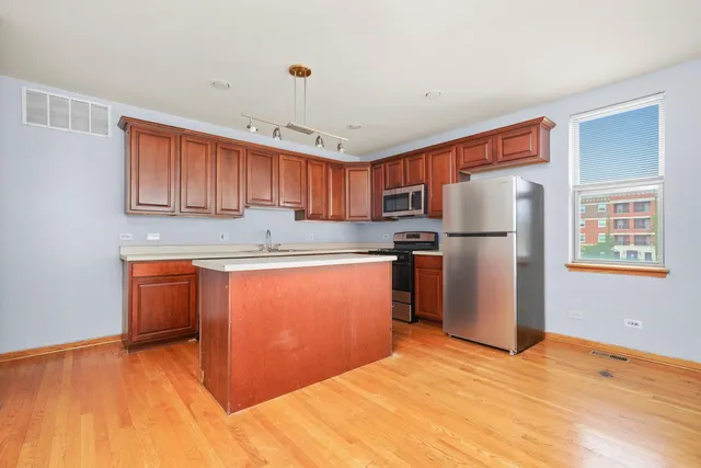a kitchen with stainless steel appliances granite countertop a refrigerator sink and cabinets
