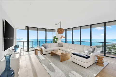 a view of balcony with floor to ceiling window plants and ocean view