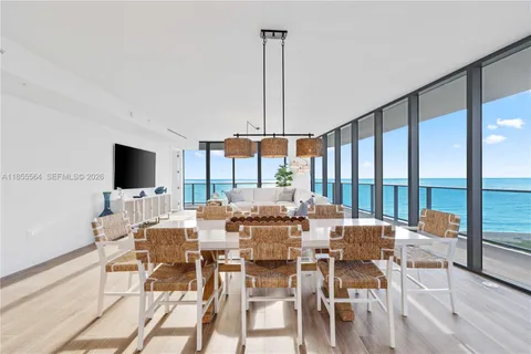 a view of balcony with floor to ceiling window plants and ocean view