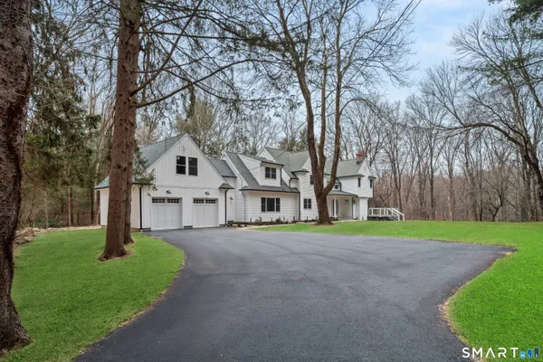 a front view of a house with a yard and trees