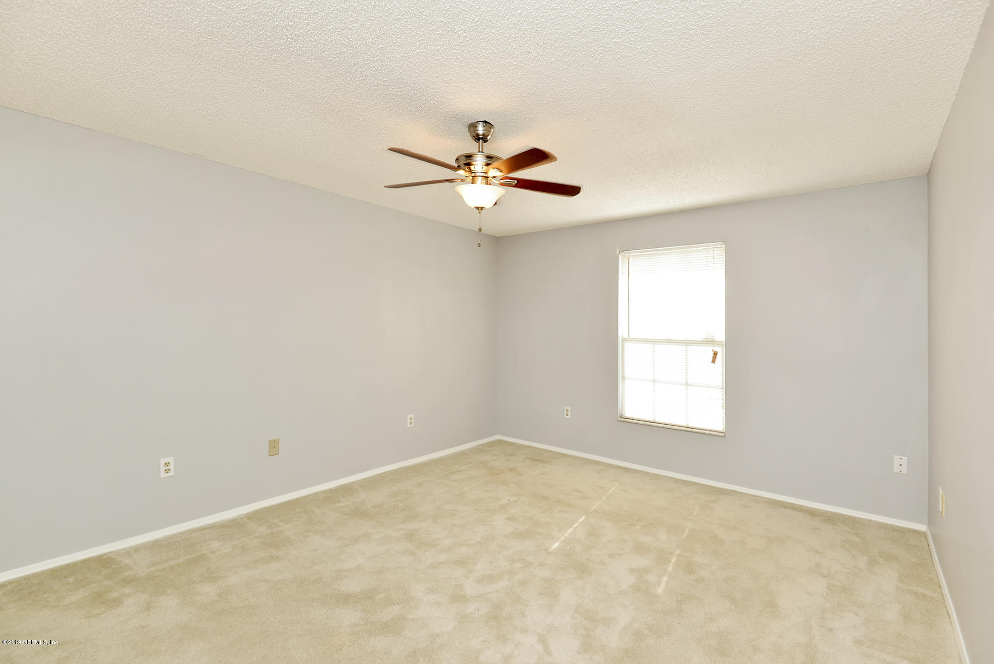 2545 Spring Lake Road West Jacksonville, FL 32210 - Photo 11 of 21 an empty room with windows and a ceiling fan