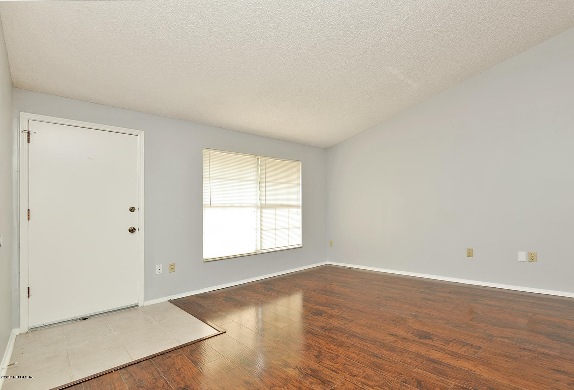 2545 Spring Lake Road West Jacksonville, FL 32210 - Photo 4 of 21 an empty room with wooden floor and windows