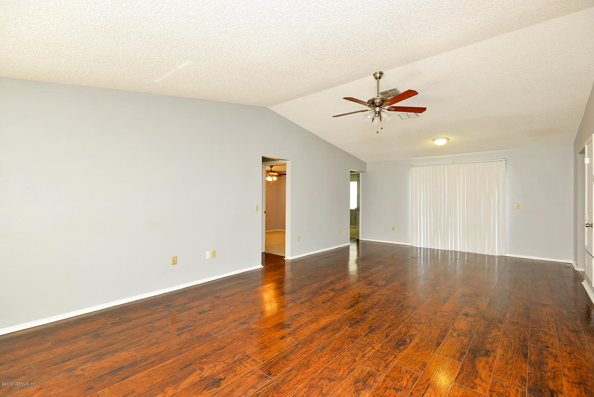 2545 Spring Lake Road West Jacksonville, FL 32210 - Photo 5 of 21 an empty room with wooden floor and a ceiling fan