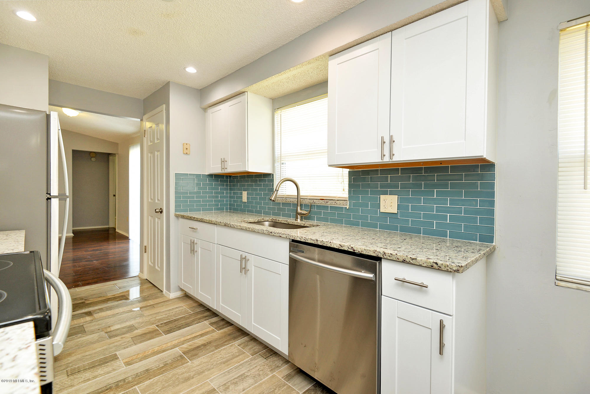 2545 Spring Lake Road West Jacksonville, FL 32210 - Photo 7 of 21 a kitchen with granite countertop a sink stove and cabinets