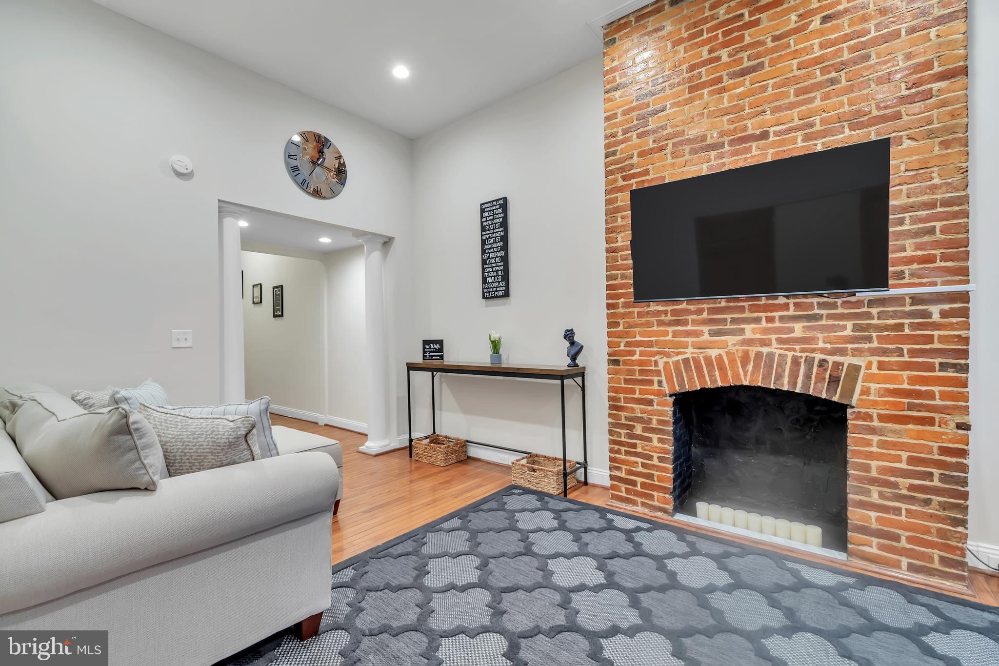 1628 North Calvert Street Baltimore, MD 21202 - Photo 24 of 63 a living room with furniture a flat screen tv and a fireplace