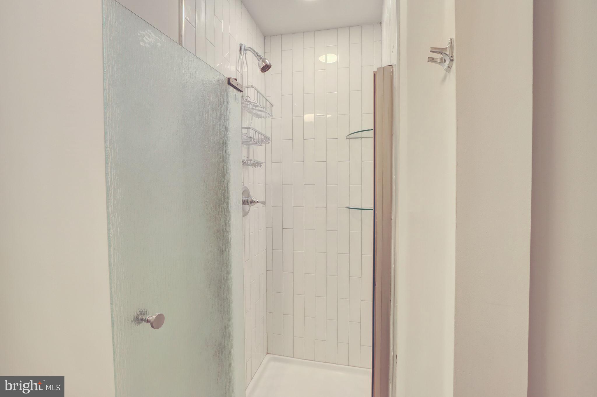 1628 North Calvert Street Baltimore, MD 21202 - Photo 31 of 63 a bathroom with a shower and a glass door