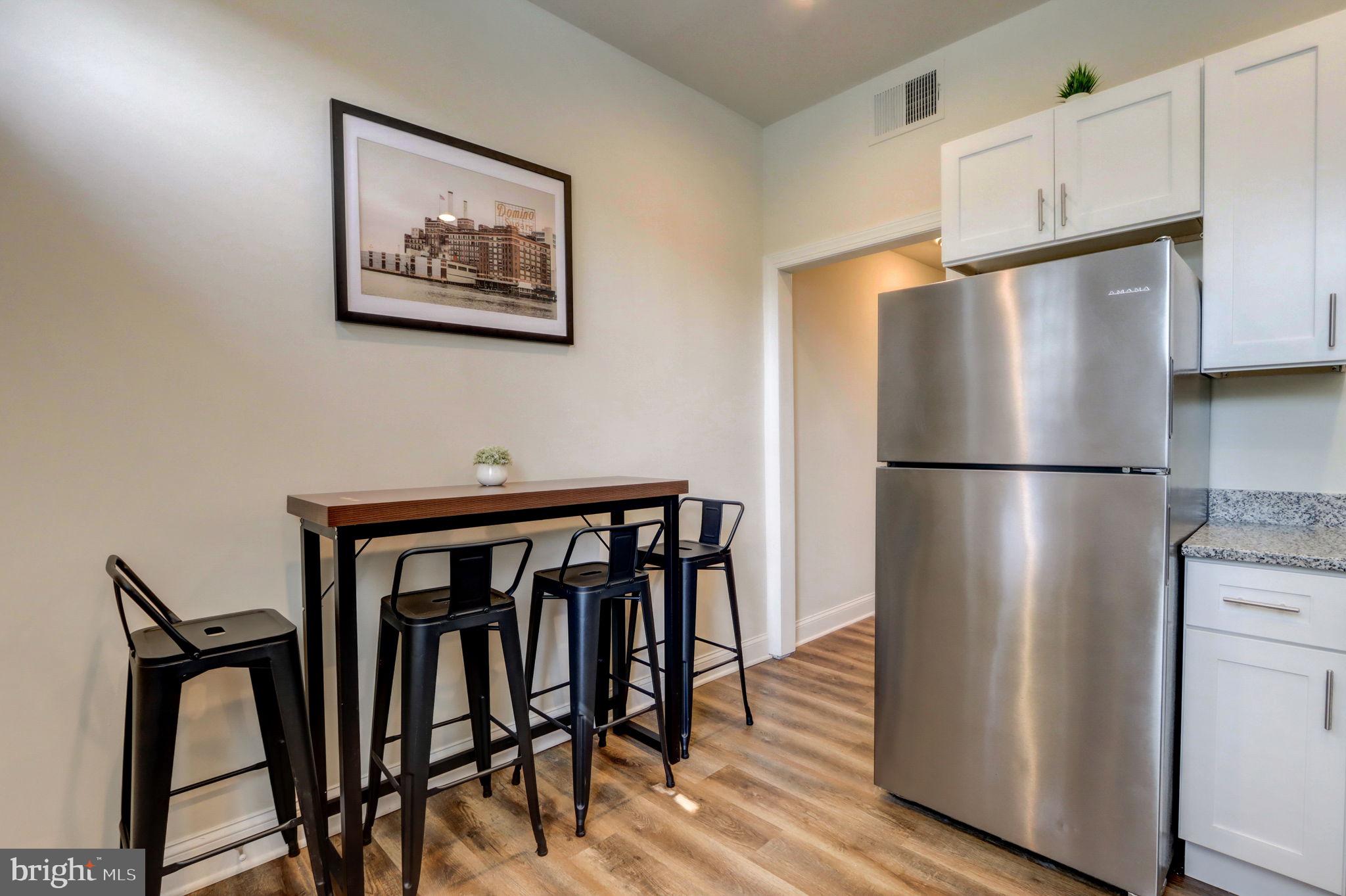 1628 North Calvert Street Baltimore, MD 21202 - Photo 8 of 63 a kitchen with stainless steel appliances granite countertop a refrigerator a stove a microwave and with wooden floors