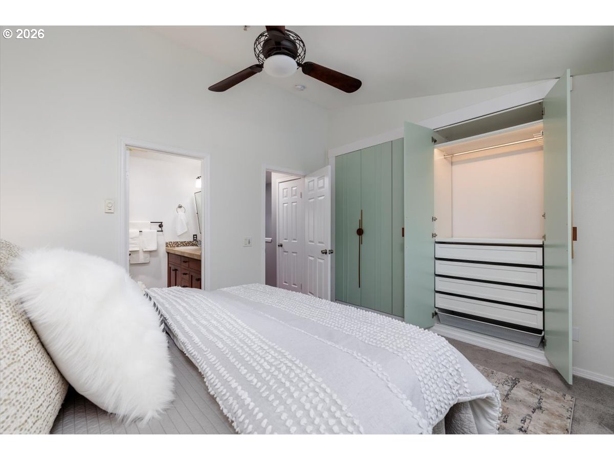 723 Southeast Fairwinds Loop, Unit BLDG H Vancouver, WA 98661 - Photo 16 of 34 a bedroom with a bed and a chandelier