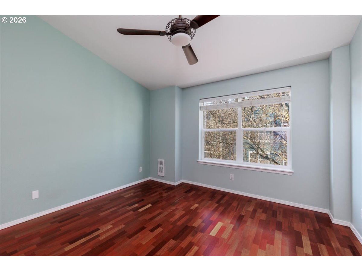 723 Southeast Fairwinds Loop, Unit BLDG H Vancouver, WA 98661 - Photo 18 of 34 a view of an empty room with wooden floor and a window