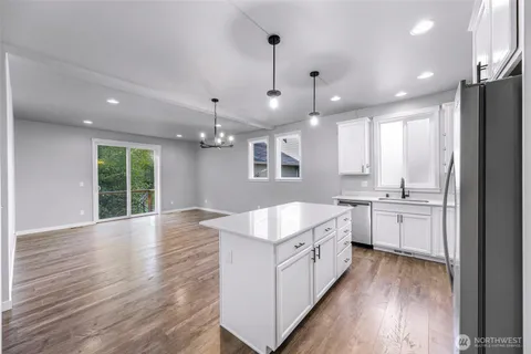 a kitchen with kitchen island a sink stainless steel appliances and cabinets