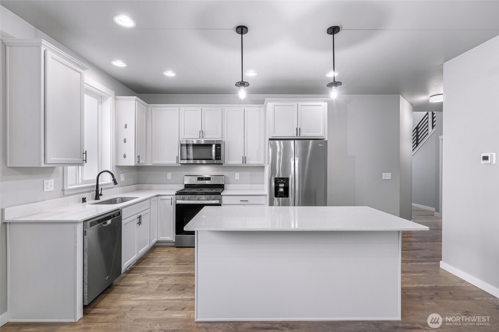 2058 Andre Court Ferndale, WA 98248 - Photo 18 of 39 a large kitchen with stainless steel appliances kitchen island a sink dishwasher a refrigerator and white cabinets with wooden floor